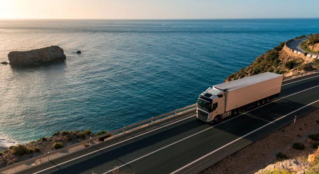 Competencia territorial de los órganos del orden social. Demanda de despido interpuesta por trabajador que presta servicios como transportista. ¿Cuándo puede elegir la circunscripción del domicilio propio? Imagen de un camión con semirremolque refrigerado por una carretera de costa