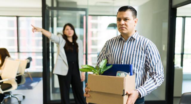 El Tribunal Supremo fija que las empresas no pueden despedir disciplinariamente a los trabajadores sin abrir trámite de «audiencia previa». Imagen de un hombre con rostro triste y con una caja en sus manos mientras le están despidiendo en la oficina