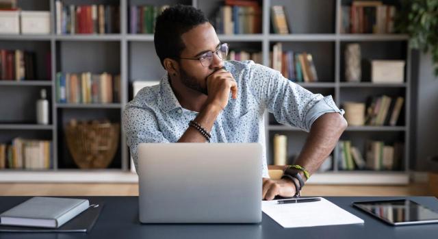 La empresa puede retractarse de un despido durante el periodo de preaviso. Imagen de un empresario africano sentado en el lugar de trabajo pensando en la solución del problema 