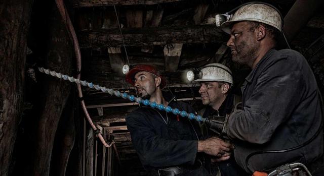 Minería del carbón: bases normalizadas de cotización 2024. Imagen de mineros trabajando con una taladradora en el interior de una mina