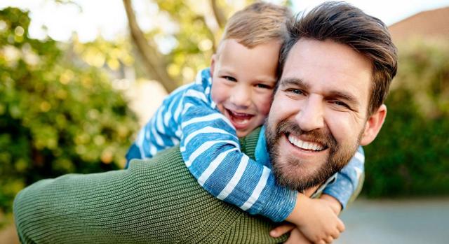 Permiso parental. Carácter retribuido. Empleados públicos. Imagen de un padre con su hijo pequeño en sus hombros muy sonrientes los dos