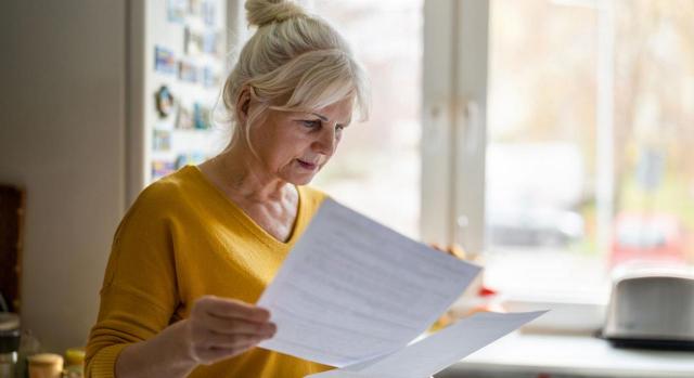 El servicio social obligatorio de la mujer no se computa para completar el periodo mínimo de cotización de 1.800 días exigido para acceder a la pensión de vejez del SOVI. Imagen de una mujer mayor mirando unos papeles con cara de preocupación