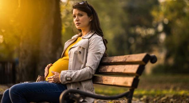 Una trabajadora embarazada debe disponer de un plazo razonable para poder impugnar su despido ante los tribunales. Imagen de una mujer embarazada sentada en un banco de un parque con cara de preocupación